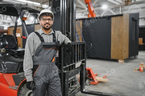 Preview: Arab engineer leaning on forklift in modular house factory