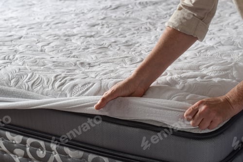 Preview: Woman putting protective mattress pad on a new mattress