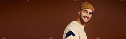 Preview: Trendy young man showcases winter fashion in stylish beanie and knitted outfit