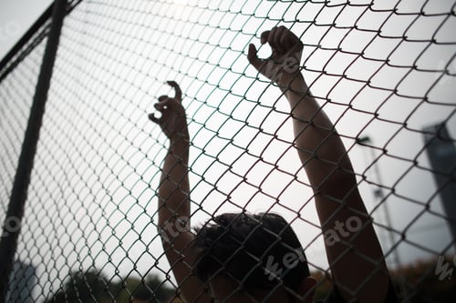 Preview: Hand with metal fence, feeling no freedom