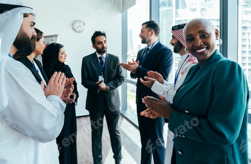Preview: Multiethnic business team applauding success in dubai office meeting