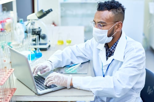 Preview: Busy scientific researcher using laptop to enter data