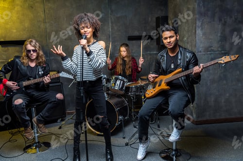 Preview: Young multiethnic rock and roll band rehearsing in musical studio