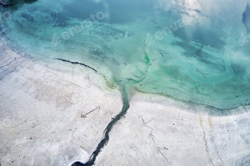 Preview: High angle shot of the turquoise water of the sea next to the shore with engravings of arrows