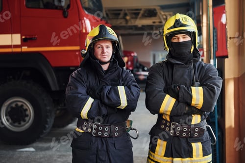 Preview: Male and female firefighters in protective uniform standing together