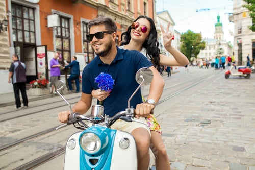 Preview: young beautiful hipster couple riding on motorbike city street