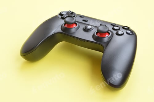 Preview: Modern black video game controller on yellow background close up