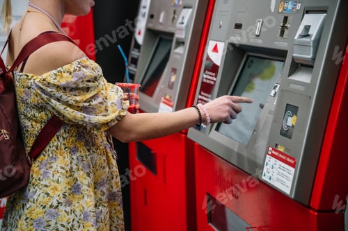 Preview: Woman with beverage buying ticket in terminal