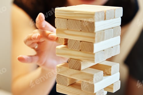 Preview: Family play board game. Hands take wooden block from tower