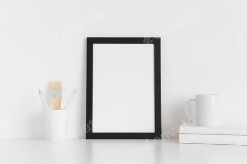 Preview: Black frame mockup with workspace accessories on a white table. Portrait orientation.