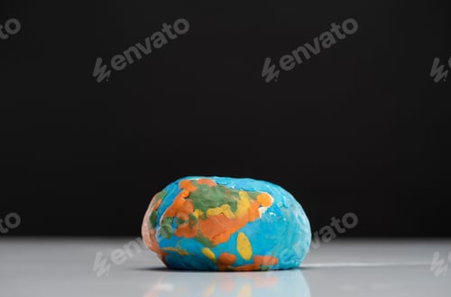 Preview: Flattened plasticine globe isolated on black, global warming concept