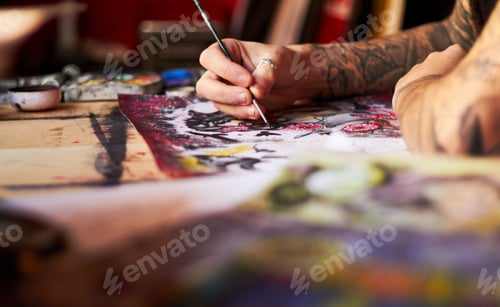 Preview: A closeup of a tattoo artist using colour and a paintbrush working on his latest piece of art work