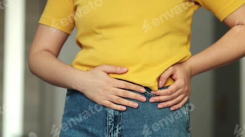Preview: Woman touching his stomach. Stomach pain and others stomach disease concept.Girl having a