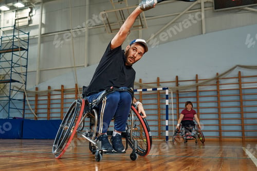 Preview: Young man in wheelchair playing tennis on court