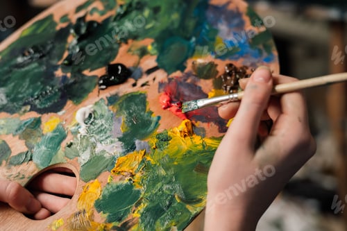 Preview: the artist paints a picture on an easel palette image
