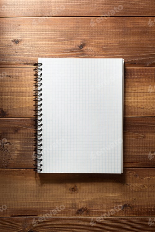Preview: checked notebook on wooden background