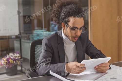 Preview: focused young architect using tablet at workplace in modern office