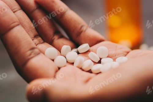 Preview: African American man holding handful of pills