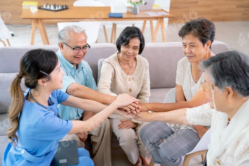 Preview: Senior man and woman join and hold hands with young nurse who take care them in clinic or hospital