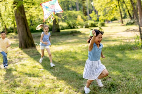 Preview: Little Asian girl running happily with a kite in the park