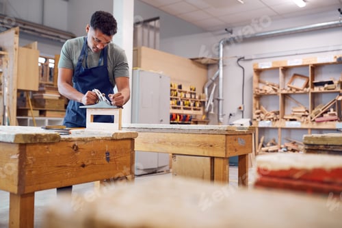 Preview: Male Student Studying For Carpentry Apprenticeship At College Using Wood Plane