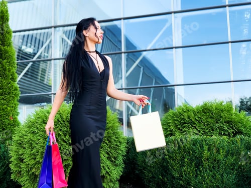 Preview: Shopping day. Woman holding colored bags near her shooping mall in black friday holiday