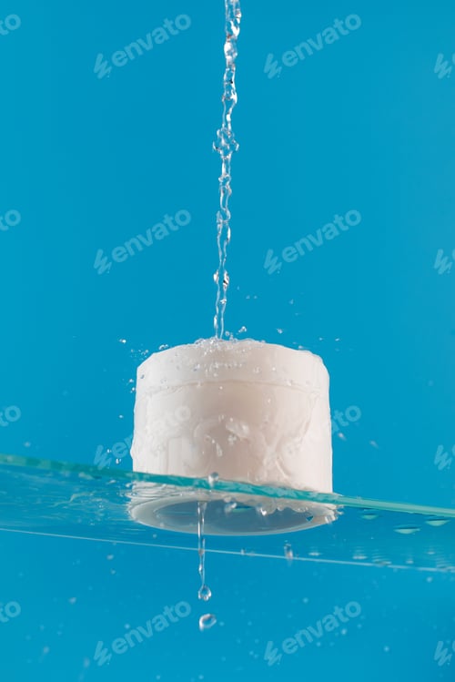 Preview: White jar with cream with place for your logo on a glass shelf with water splashes