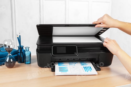 Preview: Unrecognizable young businesswoman making copies on the photocopy machine at the office