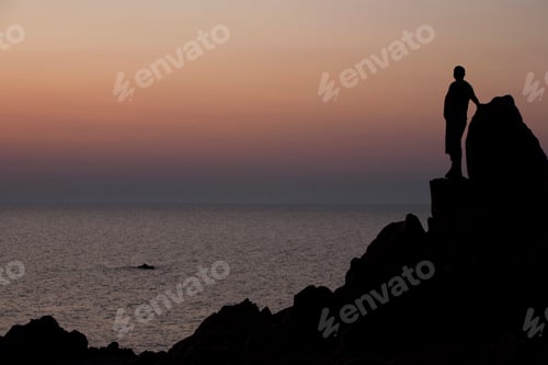 Preview: Silhouette of man on rocks looking at ocean at sunset, Capo Testa, Gallura, Sardinia, Italy