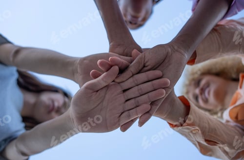 Preview: Diverse team joining hands. Mixed race group of young people in circle and putting hands together