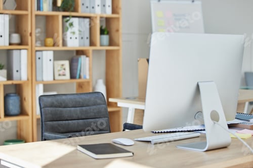 Preview: A desktop computer and keyboard standing on a table inside of a quiet empty work office during the