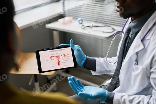 Preview: Close up black doctor explaining female reproductive system chart