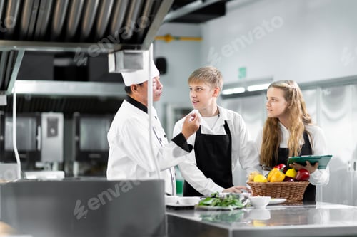 Students are learning to cook in a culinary institute with a standard kitchen