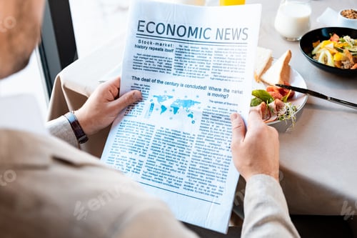 Preview: cropped view of businessman reading newspaper in cafe