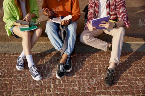 Preview: Closeup cropped shot of students group doing homework outdoors
