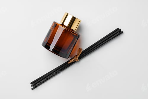 Preview: A minimalist display of essential oil and black diffuser sticks on a clean white background