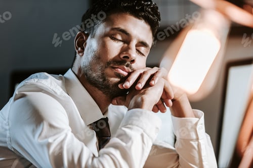Preview: low angle view of handsome bi-racial trader sleeping in office