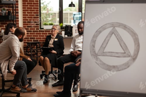 Preview: Patients sitting in circle at group therapy program while having aa meeting symbol