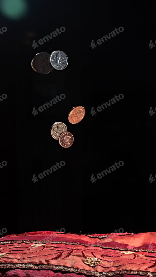 Preview: Vertical shot of coins and a red textile on the black background
