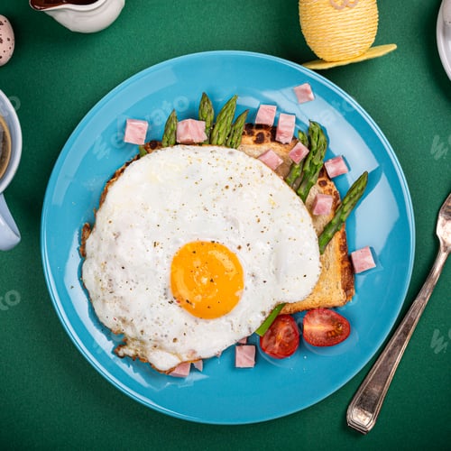 Preview: Breakfast with fried egg, bread toast, green asparagus, tomatoes and bacon