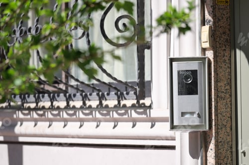 Preview: Modern intercom system near a decorative iron gate