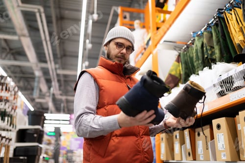 Preview: buyers a man in a hardware store chooses shoes for work at a construction site