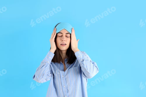 Preview: Attractive woman in sleep mask on blue background
