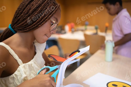 Preview: African Child cutting paper in classroom for arts and crafts