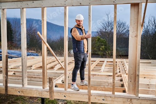 Preview: Man inspecting quality of building wooden frame house.