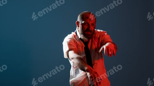 Preview: Creepy zombie growling at camera while standing on blue background