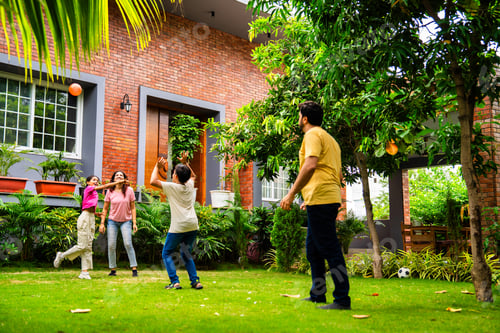 Preview: Indian parents and kids laugh and play ball game Piggy in the Middle in backyard garden
