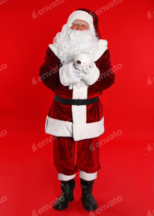 Preview: Santa Claus holding piggy bank on red background
