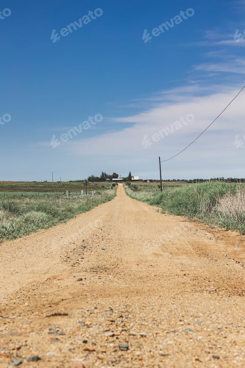 Preview: a road and power lines leading to a field, in a rural area