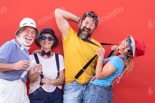 Preview: Group of adult happy people senior and middle aged playing outdoor against a red wall.